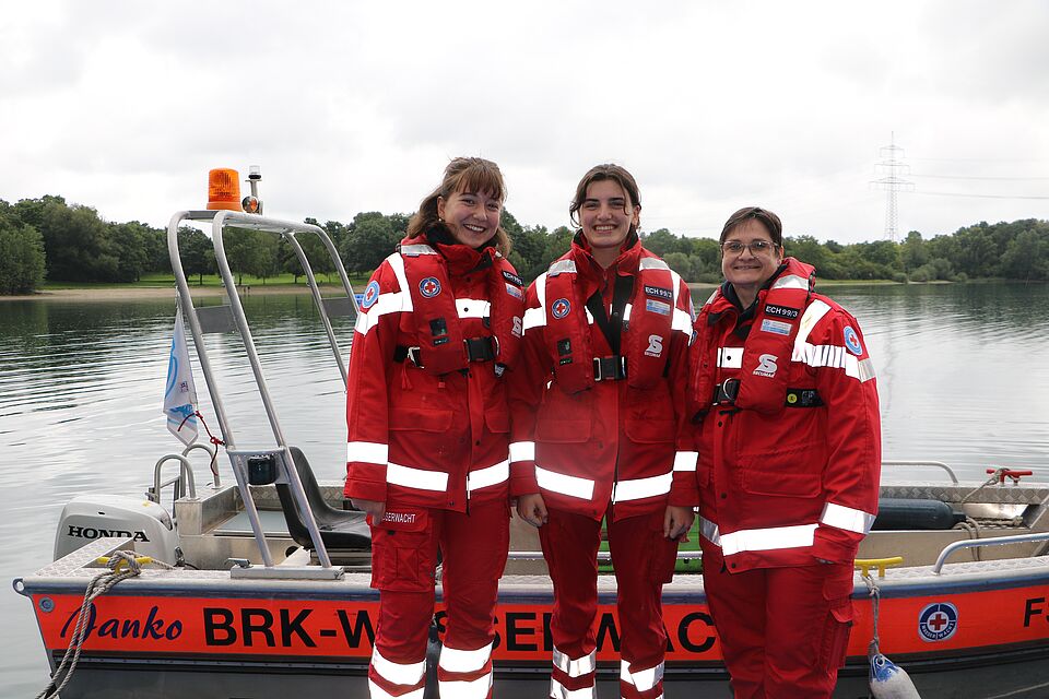  „Drei Wasserretterinnen der Wasserwacht Eching vor ihrem Boot. (Foto: Eisenmann P.,  BRK Kreisverband Freising)“