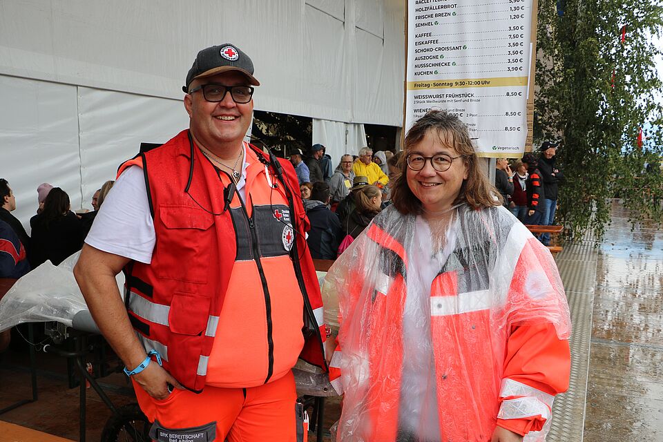 „Zwei Ehrenamtliche trotzen dem schlechten Wetter mit guter Laune und der richtigen Kleidung (Foto: Eisenmann P., BRK Kreisverband Freising)“